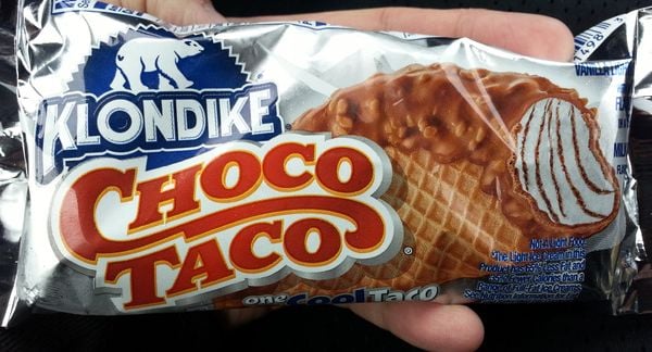 一个人拿着一个银色包装的巧克力塔可冰淇淋