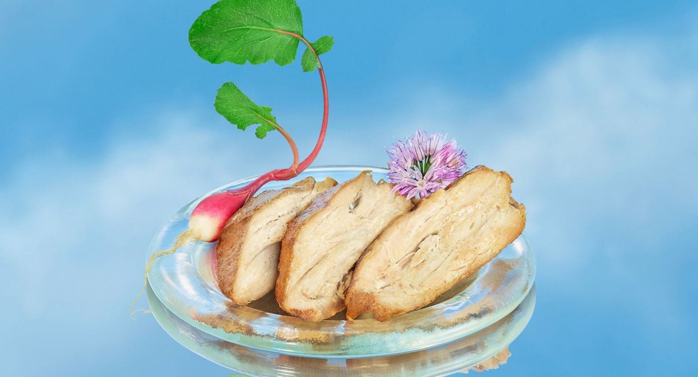 三片空气鸡放在一个玻璃盘子里，用一个小萝卜和紫色的花装饰。背景是蓝色的天空和几朵云。